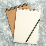 view two kraft spiral notebook with pen ice background